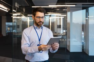 man in office utilizing innovative technology to complete tasks on tablet