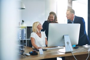 coworkers in office on computer using information technology consulting